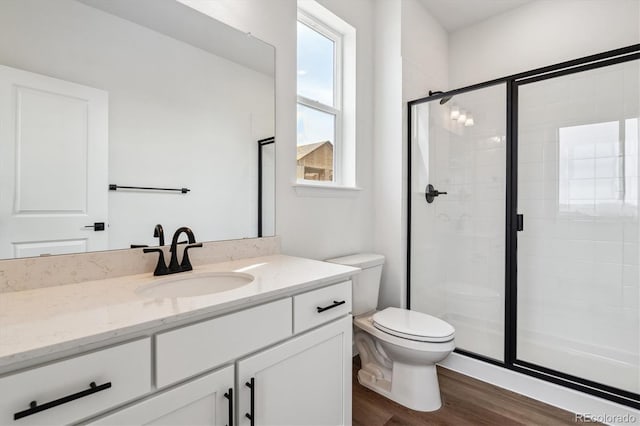 8462 Eagle River St, Littleton, CO 80125 - bathroom with toilet, a stall shower, vanity, and wood finished floors