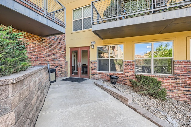 9079 E Panorama Cir Unit 419, Englewood, CO 80112 - view of exterior entry with french doors, a balcony, and brick siding