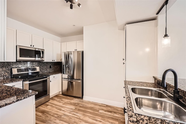 9079 E Panorama Cir Unit 419, Englewood, CO 80112 - kitchen featuring appliances with stainless steel finishes, a sink, white cabinets, decorative backsplash, and light wood-type flooring