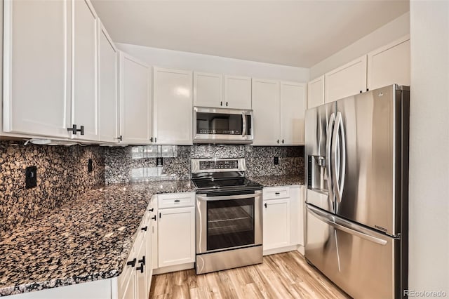 9079 E Panorama Cir Unit 419, Englewood, CO 80112 - kitchen featuring stainless steel appliances, white cabinets, backsplash, and dark stone countertops