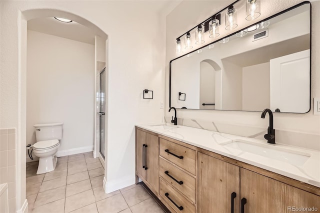 9079 E Panorama Cir Unit 419, Englewood, CO 80112 - bathroom with double vanity, toilet, tile patterned flooring, and a shower stall