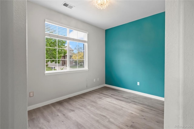 1160 S Fultondale Ct, Aurora, CO 80018 - spare room featuring wood finished floors, baseboards, and a chandelier