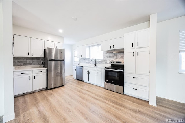 kitchen featuring white cabinets, stainless steel appliances, and light wood-type flooring