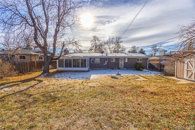 back of house with a lawn and a sunroom