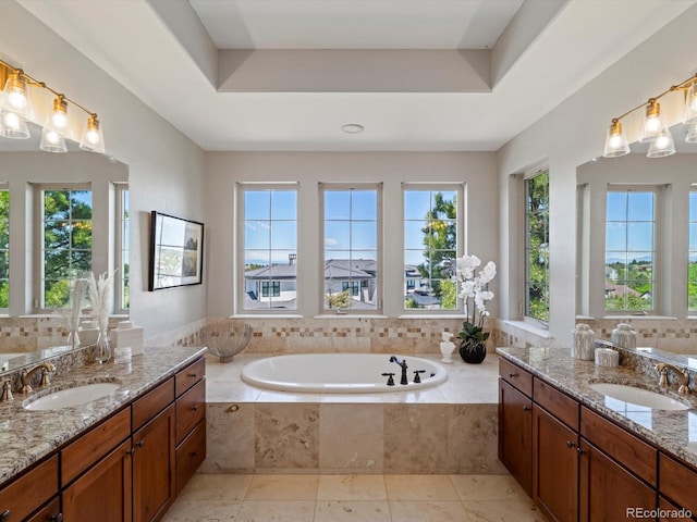 6995 S Ensenada St, Aurora, CO 80016 - bathroom with healthy amount of natural light, two vanities, and a bath