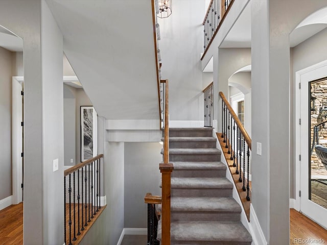 6995 S Ensenada St, Aurora, CO 80016 - stairs with wood finished floors, arched walkways, and baseboards
