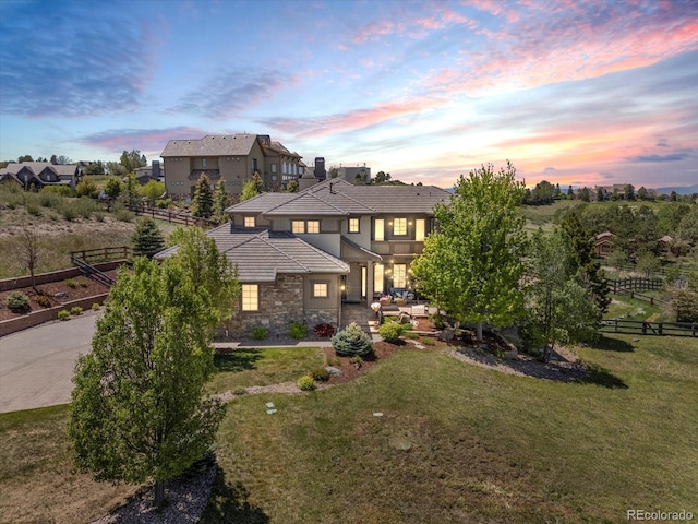 6995 S Ensenada St, Aurora, CO 80016 - view of front of home with stone siding, stucco siding, a tile roof, an outdoor hangout area, and a patio