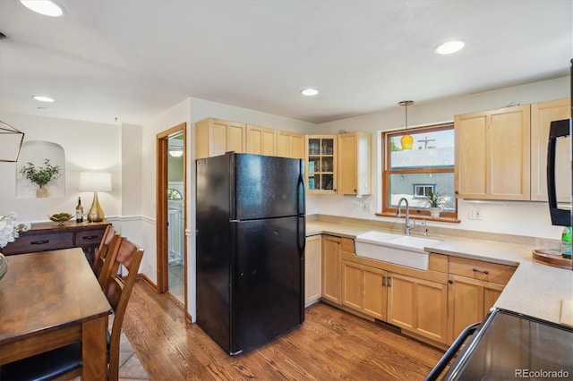 2311 W 46th Ave, Denver, CO 80211 - kitchen featuring black appliances, a sink, light brown cabinets, wood finished floors, and light countertops