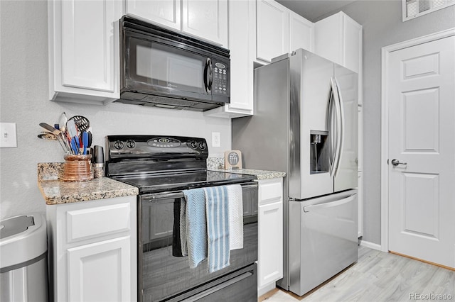 17442 Nature Walk Trl Unit 105, Parker, CO 80134 - kitchen with black appliances, light wood-style flooring, white cabinetry, and light stone counters