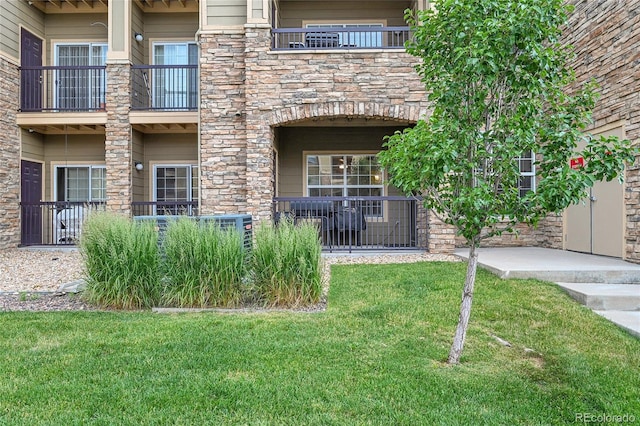 17442 Nature Walk Trl Unit 105, Parker, CO 80134 - property entrance with stone siding, a lawn, and a balcony