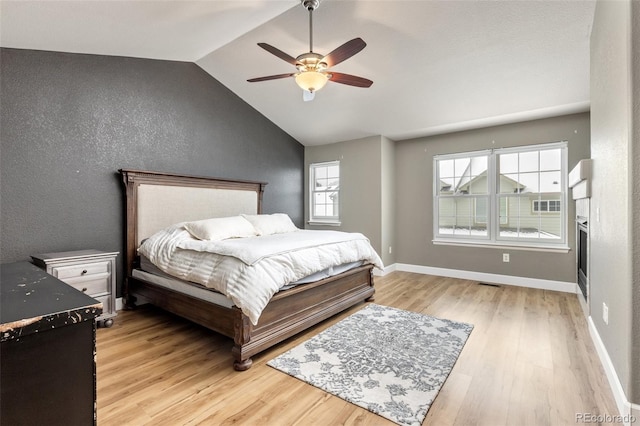 bedroom featuring ceiling fan, lofted ceiling, and light hardwood / wood-style floors