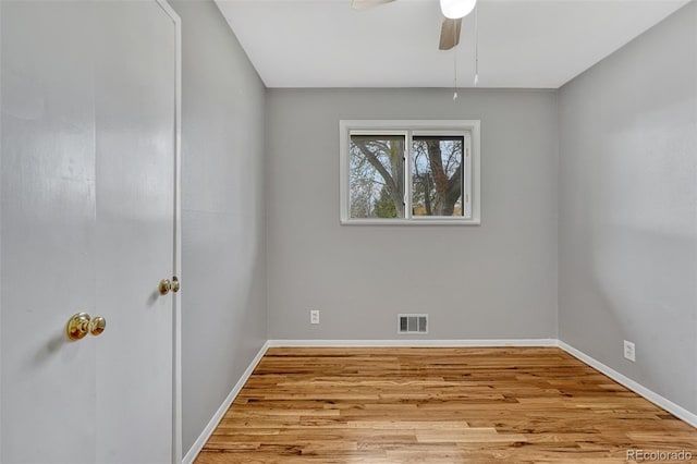 unfurnished room with wood finished floors, ceiling fan, baseboards, and visible vents