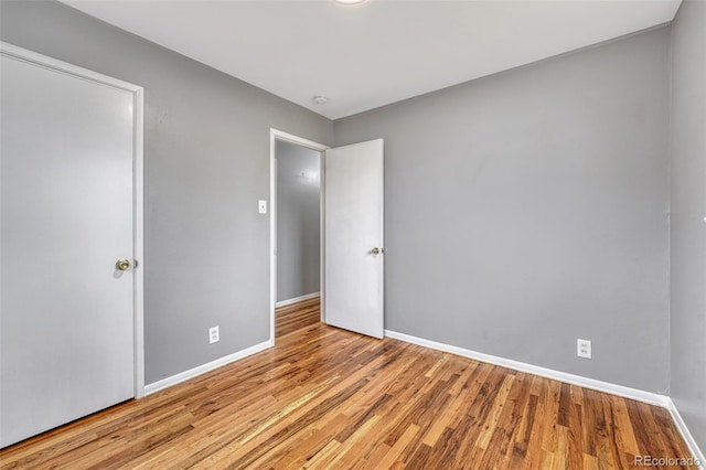 unfurnished bedroom with wood finished floors and baseboards
