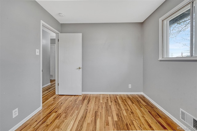 spare room featuring visible vents, baseboards, and light wood-style floors