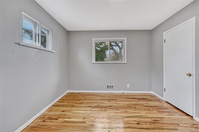 spare room with light wood-style flooring, baseboards, and visible vents