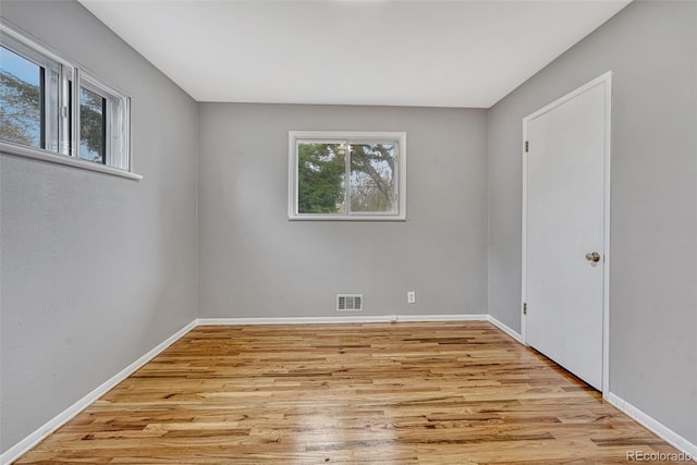 unfurnished room featuring visible vents, baseboards, and light wood-style floors