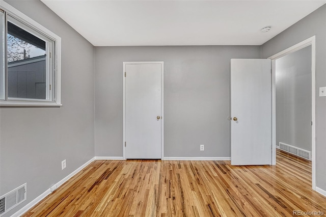 unfurnished bedroom featuring light wood finished floors, visible vents, and baseboards