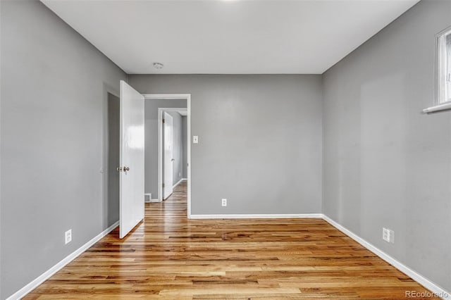 unfurnished room featuring baseboards and light wood-style floors
