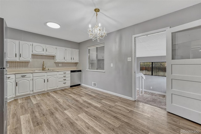 kitchen with a chandelier, light wood-style flooring, light countertops, dishwasher, and a sink