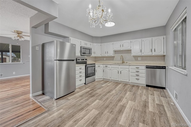 kitchen featuring light wood finished floors, light countertops, a sink, and appliances with stainless steel finishes
