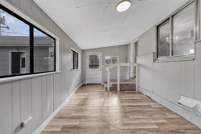empty room with wooden walls and wood finished floors