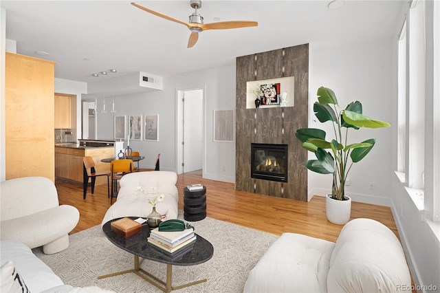 340 S Lafayette St Unit 201, Denver, CO 80209 - living room with a ceiling fan, light wood-style floors, baseboards, and a tile fireplace