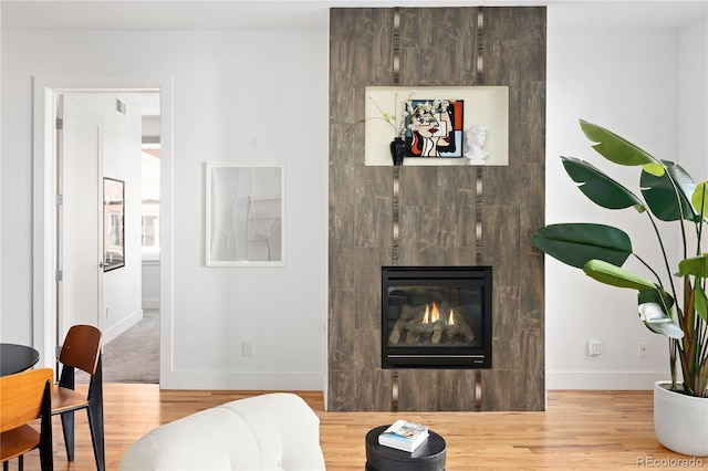 340 S Lafayette St Unit 201, Denver, CO 80209 - living area with baseboards, wood finished floors, and a tile fireplace