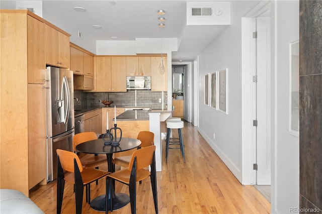 340 S Lafayette St Unit 201, Denver, CO 80209 - kitchen with stainless steel appliances, light brown cabinetry, tasteful backsplash, light wood-type flooring, and a sink