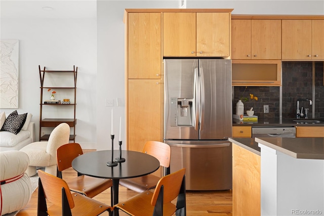 340 S Lafayette St Unit 201, Denver, CO 80209 - kitchen featuring appliances with stainless steel finishes, dark countertops, tasteful backsplash, a sink, and light wood-style floors