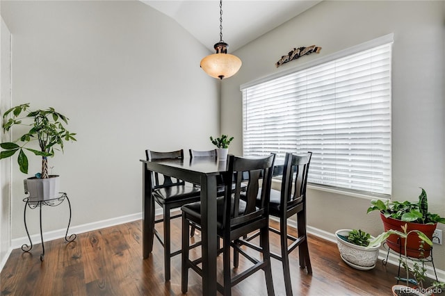 dining area with dark hardwood / wood-style flooring and vaulted ceiling