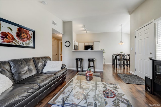 living room with vaulted ceiling and dark hardwood / wood-style flooring