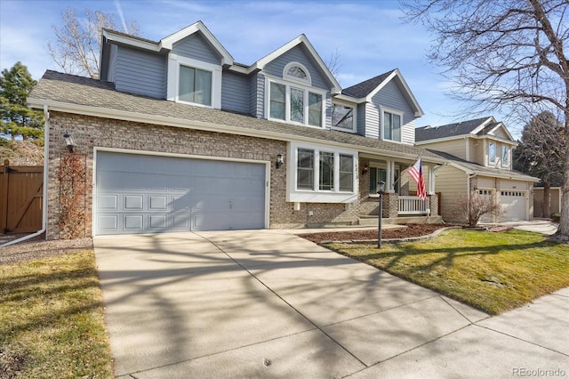 view of front of house with covered porch, a garage, and a front lawn