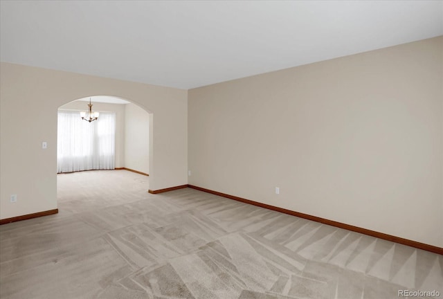 unfurnished room with light carpet and a chandelier