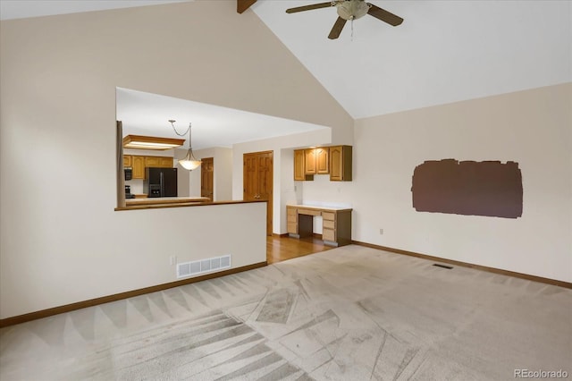 unfurnished living room with ceiling fan, beam ceiling, light colored carpet, and high vaulted ceiling