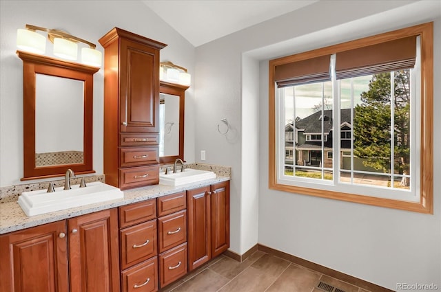 bathroom with tile patterned flooring, vanity, and vaulted ceiling