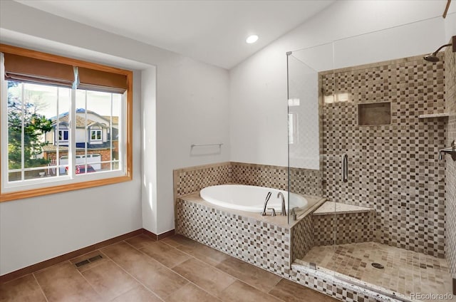 bathroom with tile patterned floors, vaulted ceiling, and separate shower and tub