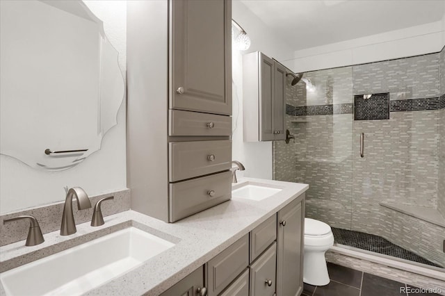 bathroom with tile patterned flooring, vanity, toilet, and a shower with door