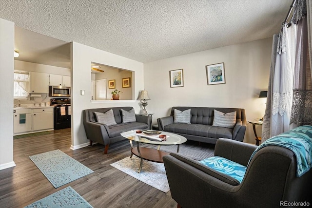 living room with dark wood-type flooring, sink, and a textured ceiling