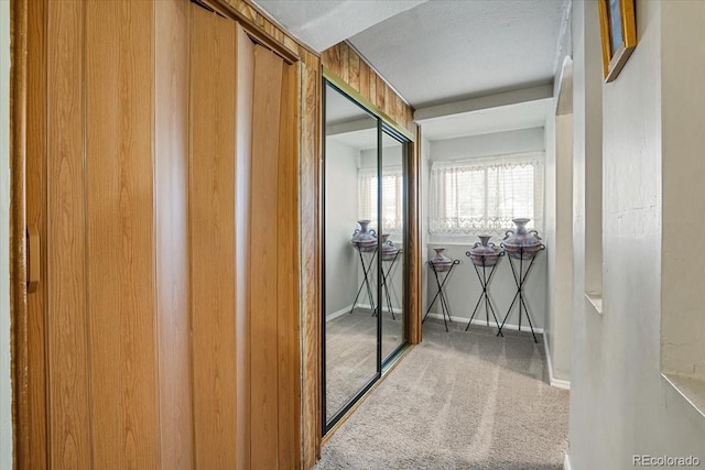 corridor with carpet flooring and a textured ceiling