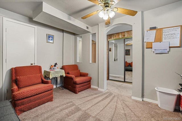 living area with light colored carpet and ceiling fan