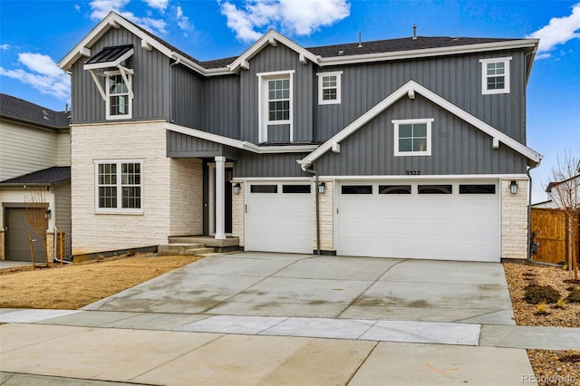 9322 Quaker St, Arvada, CO 80007 - view of front of home with stone siding, fence, an attached garage, board and batten siding, and driveway