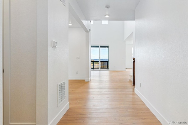 9322 Quaker St, Arvada, CO 80007 - hallway featuring baseboards, a towering ceiling, visible vents, and light wood finished floors