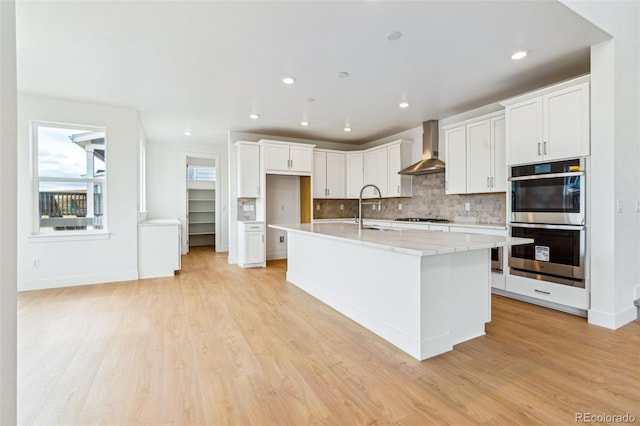 9322 Quaker St, Arvada, CO 80007 - kitchen with light countertops, a sink, stainless steel double oven, gas cooktop, and wall chimney range hood