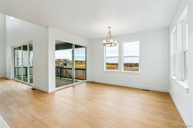 9322 Quaker St, Arvada, CO 80007 - empty room with an inviting chandelier, light wood-style flooring, baseboards, and visible vents
