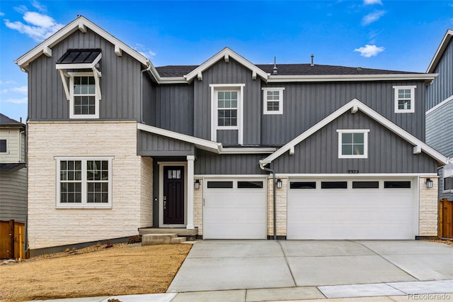 9322 Quaker St, Arvada, CO 80007 - view of front of property featuring stone siding, board and batten siding, driveway, and fence