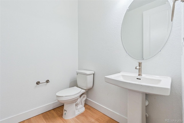 9322 Quaker St, Arvada, CO 80007 - half bathroom featuring baseboards, wood finished floors, and toilet