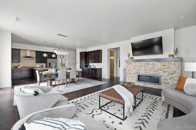 living room featuring wood-type flooring and a stone fireplace