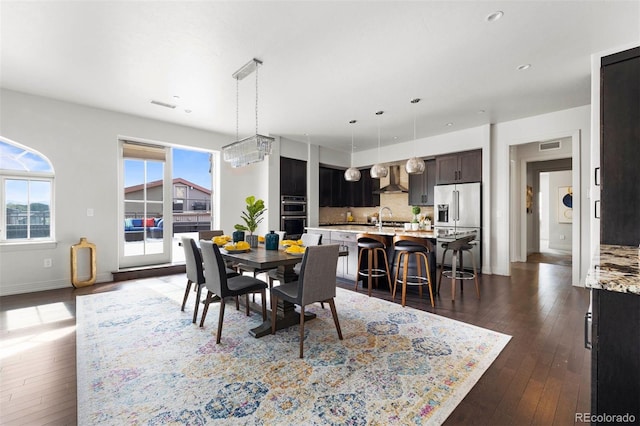 dining space with sink and dark wood-type flooring