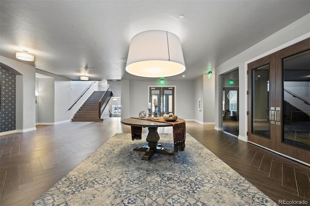 rec room featuring dark parquet floors, french doors, and a textured ceiling