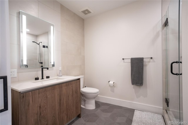 bathroom with toilet, vanity, walk in shower, tile walls, and tile floors